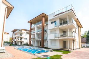 an apartment building with a swimming pool in front of it at Sprint Apartman in Siófok