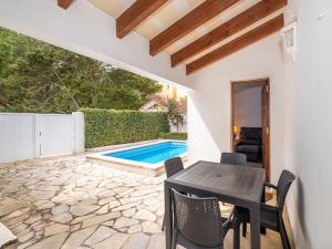 a patio with a table and chairs and a swimming pool at Chalet La Rosa in Cala Blanca