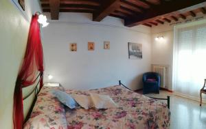 Schlafzimmer mit einem Bett und einem Fenster in der Unterkunft Finestra sulla val d'Orcia in San Quirico dʼOrcia
