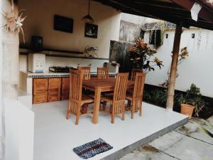 - une cuisine avec une table et des chaises en bois dans l'établissement Honey Home Stay, à Canggu