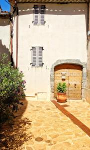 a large white building with a wooden garage at Ramatuelle Maison de Village in Ramatuelle