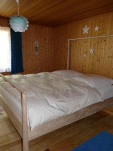 a bed in a wooden room with stars on the wall at Chalet Bergmann in Bürchen