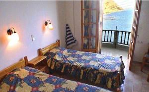 a bedroom with two beds and a balcony at Diamont Studios in Agia Galini
