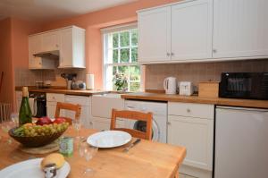 een keuken met een tafel en een fruitschaal bij Rhoda`s Cottage in Creggans