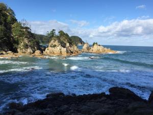 a view of the ocean with rocks in the water at Iwamino Oyado lucere in Uradome