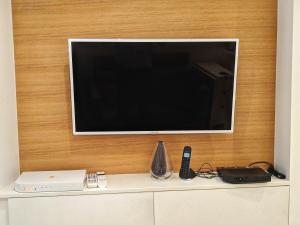 a flat screen tv on a wall above a shelf at Ramatuelle Maison de Village in Ramatuelle +4 photos