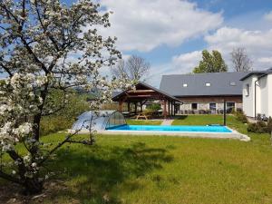 un patio con piscina y una casa en Apartmány Vízmberk en Velké Losiny