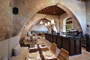 a restaurant with tables and chairs in a stone building at Polis 1907 by Louis Hotels in Polis Chrysochous