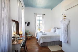 a bedroom with a bed and a desk and a mirror at Polis 1907 by Louis Hotels in Polis Chrysochous