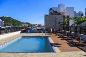 a swimming pool on the roof of a building at Champagnat Praia Hotel in Vila Velha