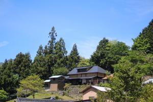 a house on top of a hill with trees at Guesthouse boro-ya in Otoyocho