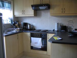 a kitchen with a stove with a white towel on the oven at Malleson Garden Cottage in Cape Town