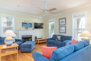 sala de estar con sofás azules y chimenea en Little Tara en Tybee Island