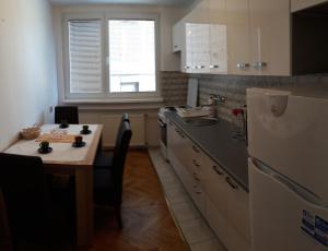 Il comprend une petite cuisine équipée d'une table et d'un réfrigérateur. dans l'établissement Apartment Ambrela 2, à Sarajevo