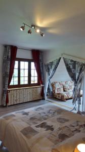 a bedroom with a bed in a room with windows at La Marmotte de la Tour in Hermillon