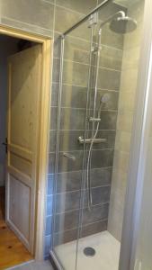 a shower with a glass door in a bathroom at La Marmotte de la Tour in Hermillon