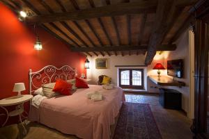 a bedroom with a large bed with red walls at Porta Vivaria Orvieto- Private Parking in Orvieto