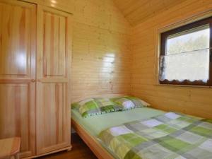 Jezierzany的住宿－Domki Letniskowe WIKTORIA，一间小卧室,配有床和窗户