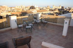 a patio with chairs and tables on a balcony at Santa Barbara Guesthouse in Alicante