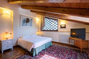 a bedroom with a bed and a flat screen tv at La Quercia - BolognaRooms in Sasso Marconi