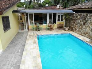 a swimming pool in front of a house at Ipê Suites Juquehy in Juquei +24 photos