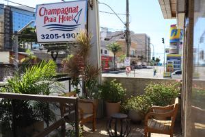 um sinal para uma cabana de pizza com cadeiras e plantas em Champagnat Praia Hotel em Vila Velha