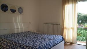 a bedroom with a bed in front of a window at Appartamenti La corte al Mare in Massa