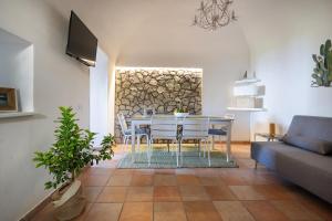 uma sala de estar com uma mesa e cadeiras e um sofá em Nonna Carmela Apartment em SantʼAgata sui Due Golfi