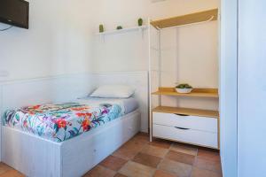a small bedroom with a bed and a night stand at Nonna Carmela Apartment in SantʼAgata sui Due Golfi
