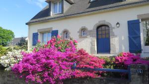 une maison avec des fleurs roses devant elle dans l'établissement Mer et campagne, à Ploemeur