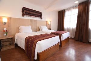 A bed or beds in a room at Hotel Prisma Cusco