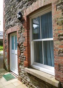 um edifício de tijolos com duas janelas em 2 Bell Street em Talgarth