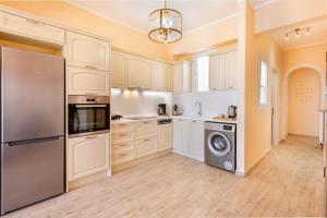 a kitchen with white cabinets and a washer and dryer at Anaria Gold Suite in Ermoupoli +31 photos
