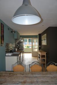 een keuken met een tafel en stoelen en een grote lamp bij Maison D'ide in Bouillon