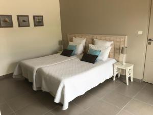 1 dormitorio con 1 cama blanca grande con almohadas en Les sables en Santec