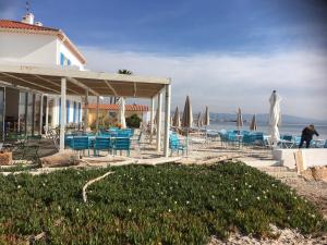 a building with blue chairs and umbrellas on the beach at Hôtel Lido Beach in Hyères
