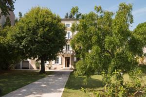 une grande maison blanche avec des arbres devant elle dans l'établissement La Saudade, à Saint-Péray