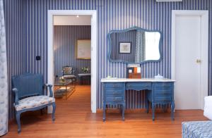 a bedroom with a blue dressing table and a mirror at Agumar in Madrid
