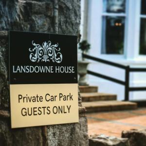 ein Schild auf einem Baum vor einem Haus in der Unterkunft Lansdowne House with Private Car Park in Llandudno