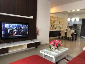 - un salon avec une télévision et une table fleurie dans l'établissement 14 Place Sukhumvit Suites, à Bangkok