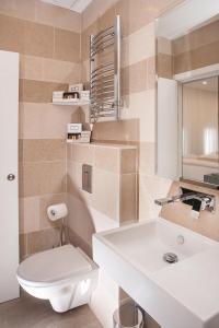 La salle de bains est pourvue de toilettes blanches et d'un lavabo. dans l'établissement NOX Golders Green, à Londres