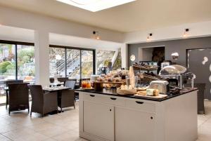a restaurant with a counter with food on it at Hôtel & Spa Les Mouettes in Argelès-sur-Mer
