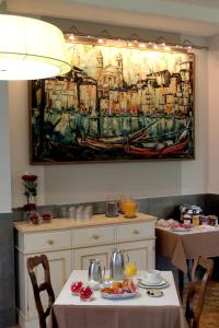 a kitchen with a table with a painting on the wall at Hotel de La Paix in Corte