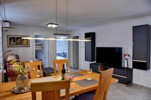 a dining room with a table and a television at Lana & Ena Apartments in Kotor