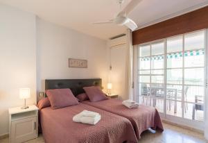 a bedroom with a large bed with two towels on it at Sandy Playa Golf Málaga con Parking in Málaga