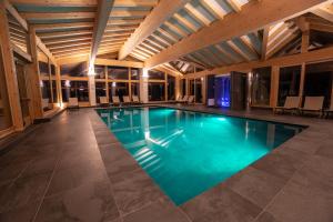 uma piscina com água azul num edifício em Caminetto Mountain Resort em Lavarone