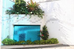 a blue swimming pool on a white tile wall at Maison Florense Hotel in Sao Paulo