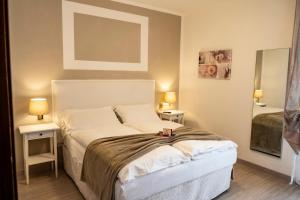 a bedroom with a bed with two tables and two lamps at Hotel Garni Bel Sito in Tremosine Sul Garda