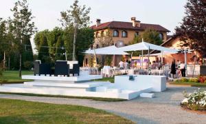 a group of tables and umbrellas in a park at Tenuta La Cascinetta in Buriasco