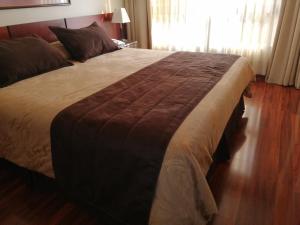 a neatly made bed in a bedroom at Hotel Diego de Velazquez in Santiago